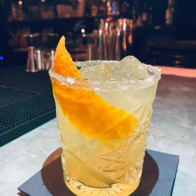 Elegant cocktail with orange garnish for networking receptions and events.