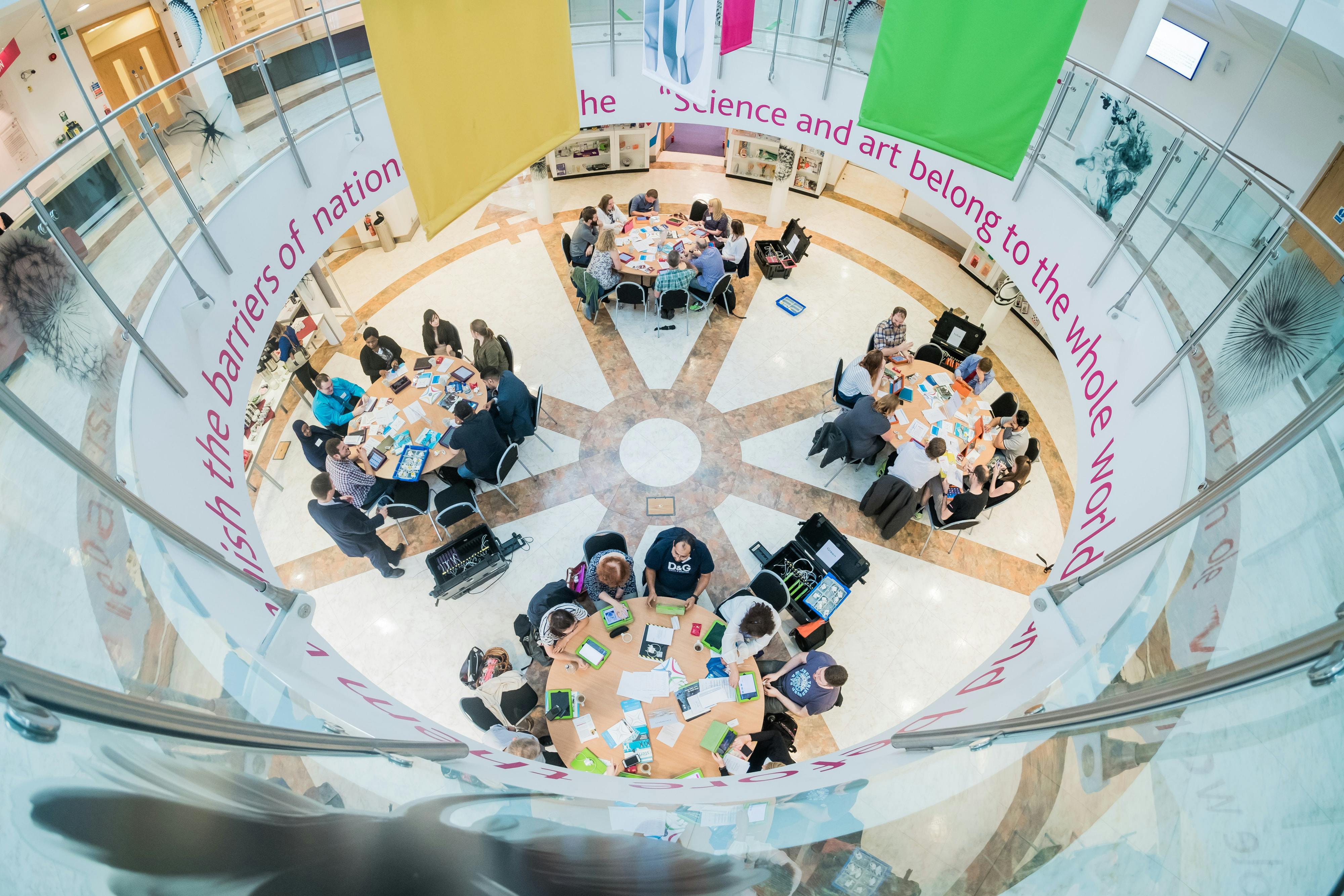 Vibrant meeting space with round tables at National STEM Learning Centre for workshops.