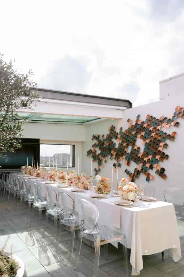 Elegant long table setup in Met Lounge for upscale events with floral decor and candles.