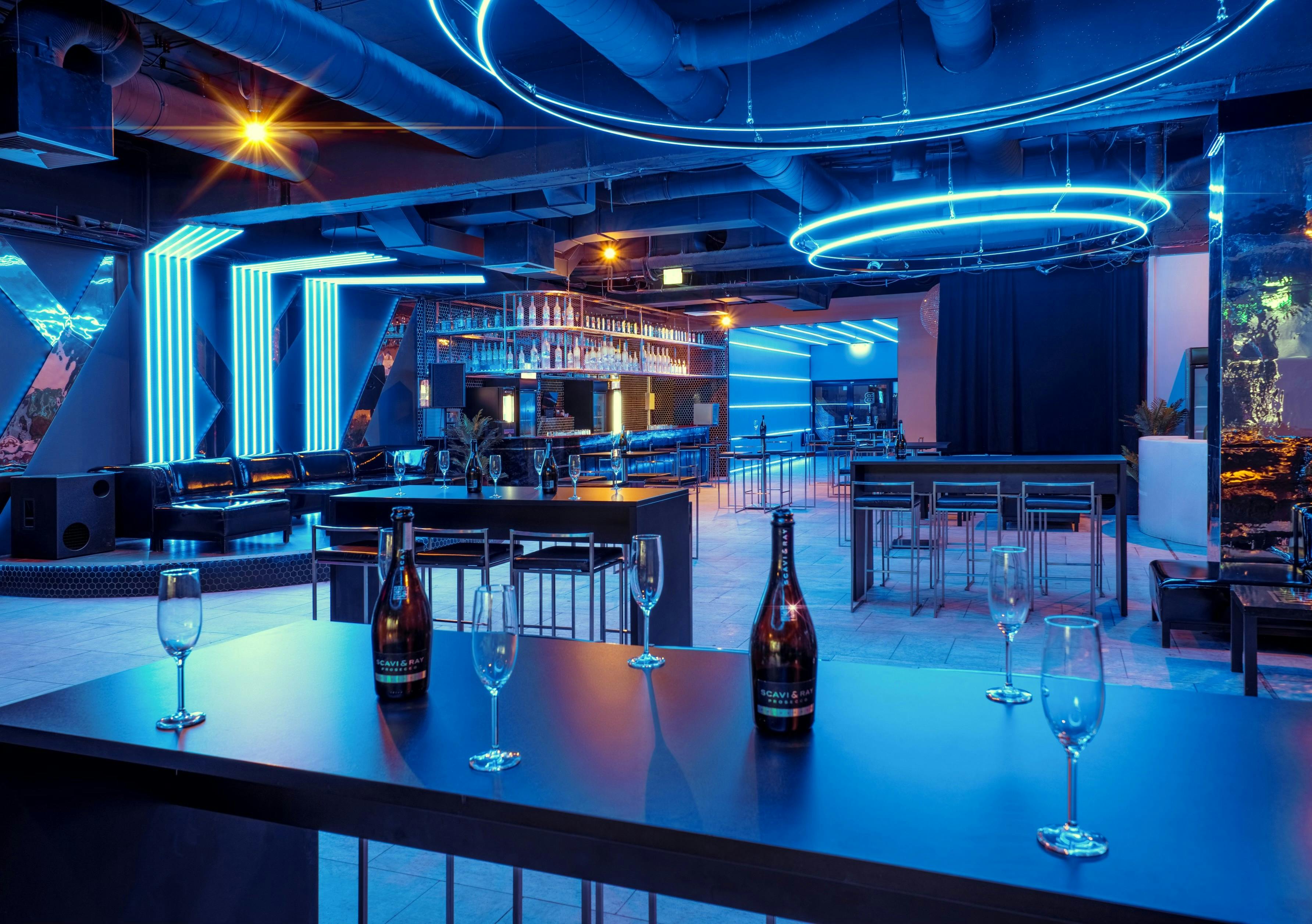 Modern event space with blue lighting, ideal for networking and cocktail receptions.