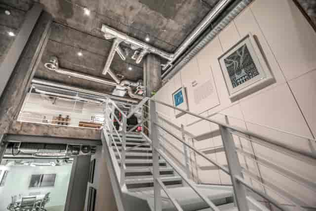 Modern industrial event space with exposed pipes, ideal for creative meetings and networking.