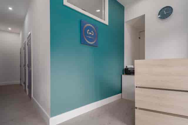 Modern hybrid meeting space with teal wall, ideal for professional events and meetings.