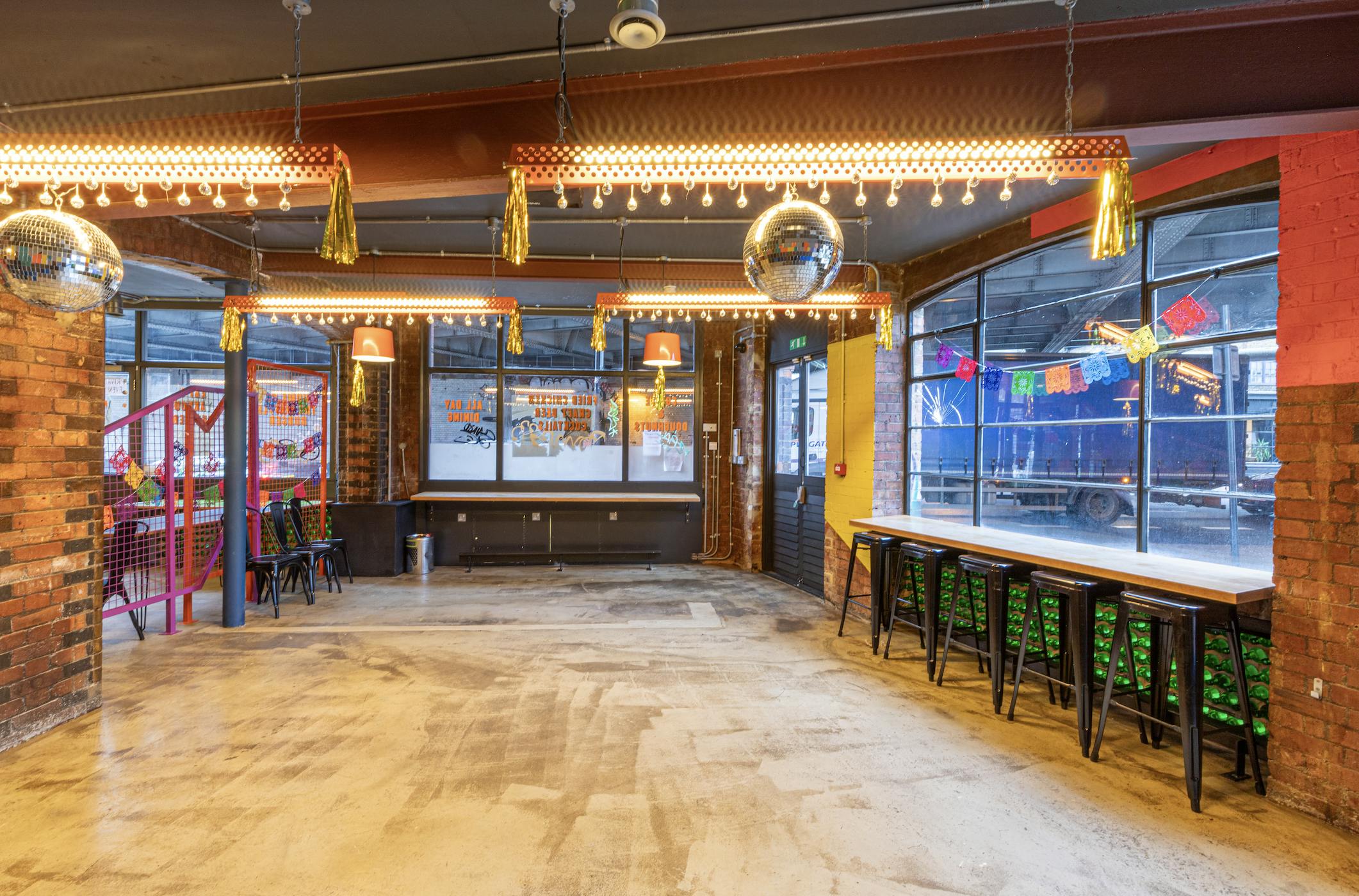 Versatile event space with exposed brick and vibrant decor, perfect for gatherings and parties.