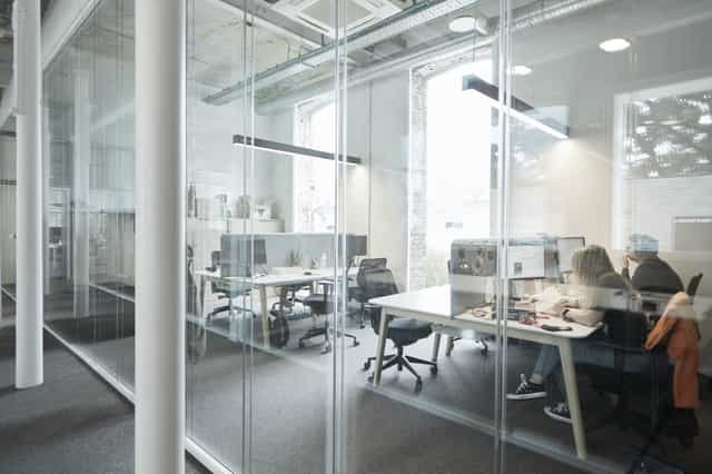Modern open office space with glass meeting rooms, ideal for corporate events and workshops.