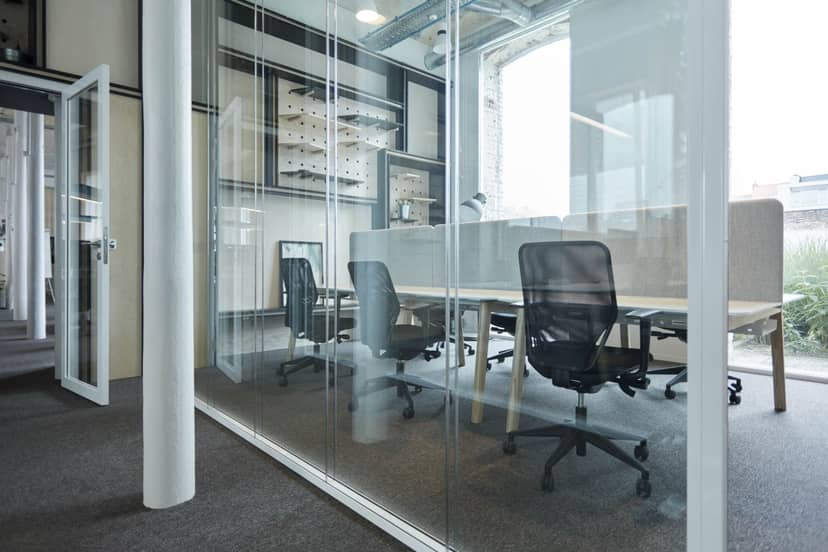 Modern meeting room with glass walls at Watt Factory for collaborative events.