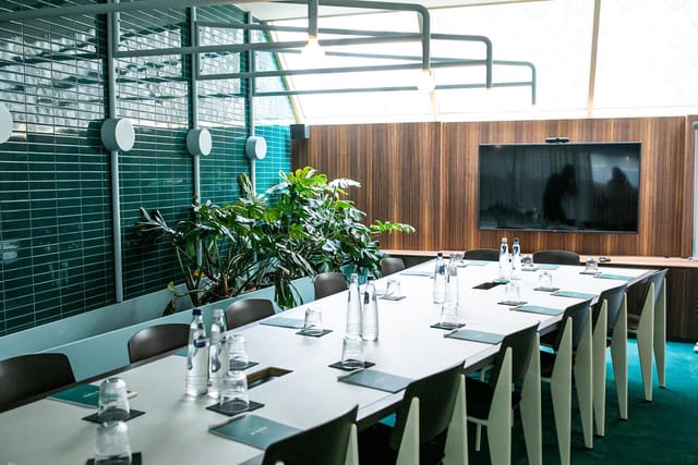 Modern conference room at Yalo Hotel, featuring a long table and advanced presentation screen.