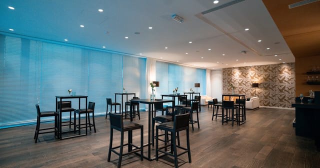 Modern event space Rijvissche with high-top tables, perfect for networking and receptions.