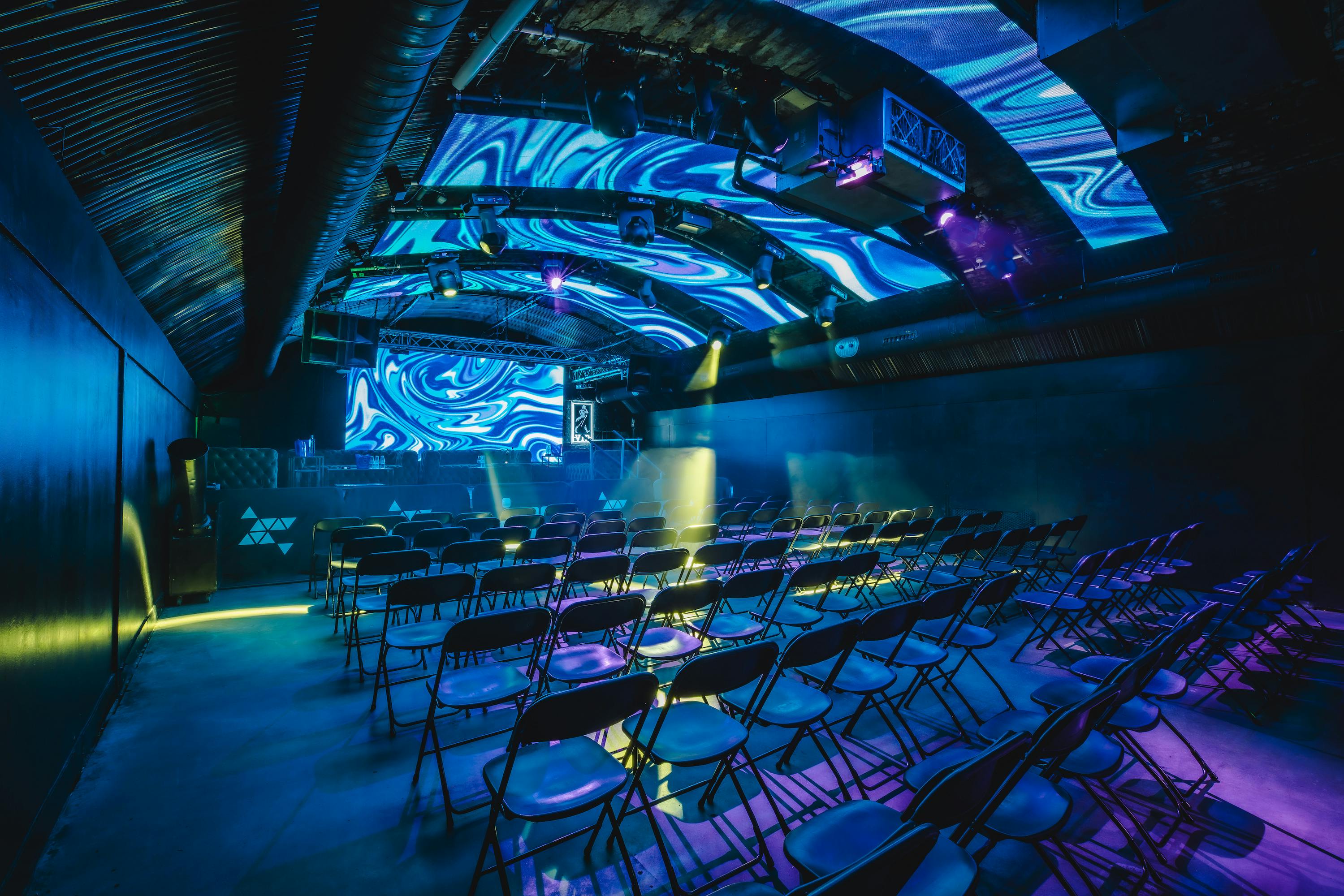 Fire Mirror Arch event space with vibrant lighting, ideal for conferences and creative events.