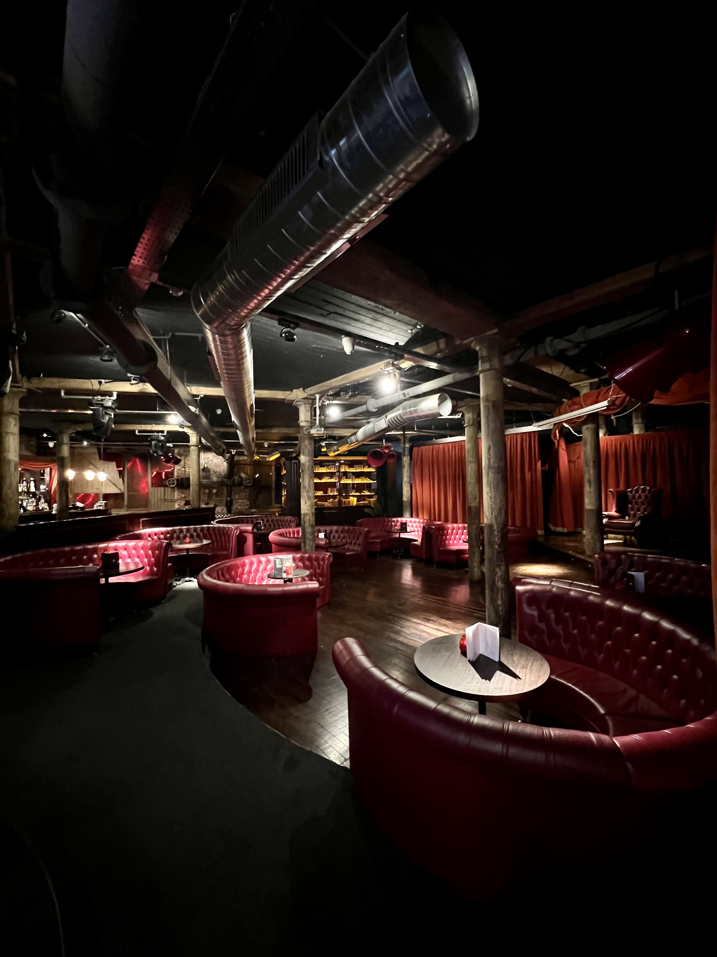Stylish Whiskey Down venue with plush red seating for exclusive events and gatherings. - Banner