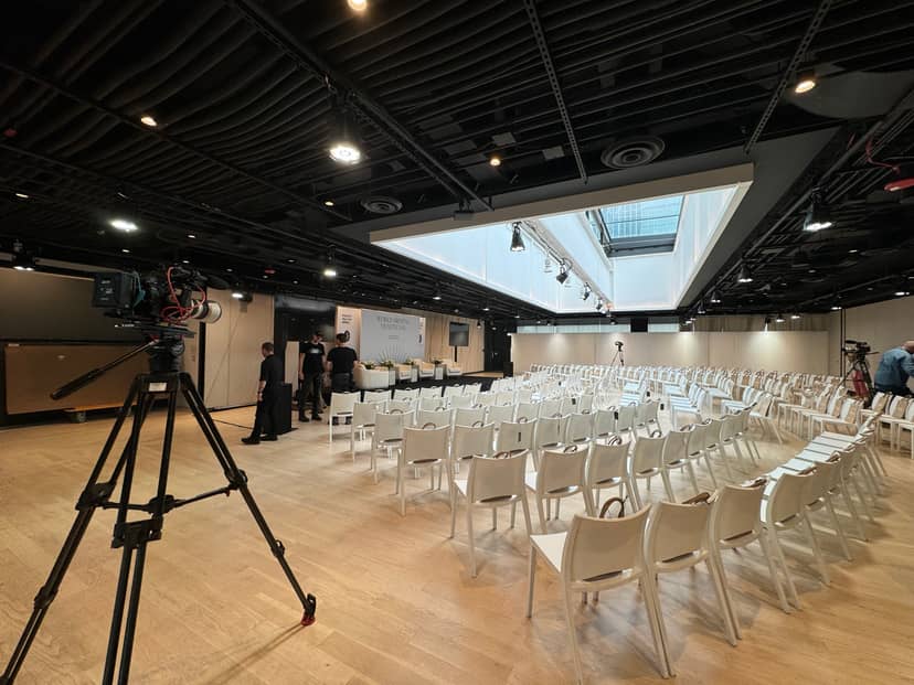 Tisch Skylights event space with white chairs, bright lighting for hybrid meetings.