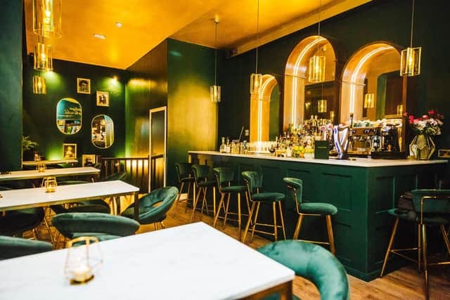 Stylish Tabula Rasa Bar with green walls, ideal for networking events and gatherings.