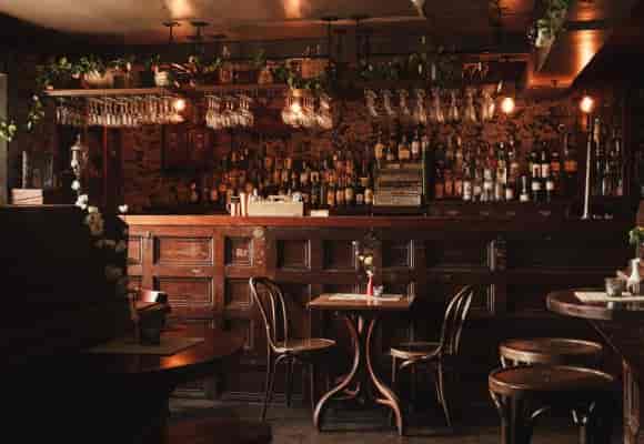 Cozy rustic bar with warm lighting, ideal for networking events and gatherings.
