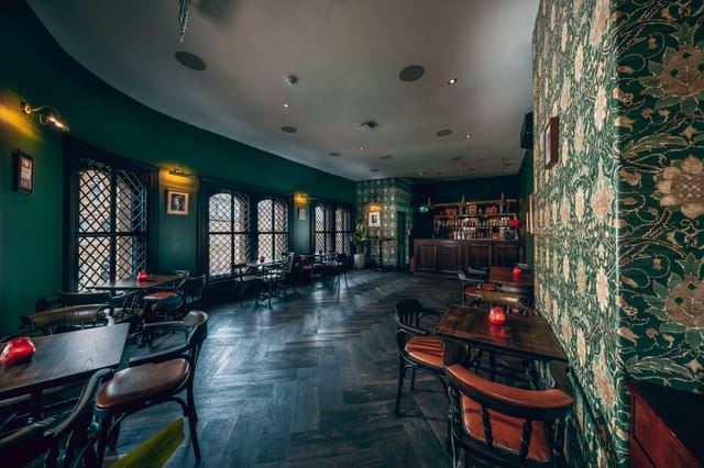 Stylish Maven Bar with green floral walls, perfect for cocktail receptions and meetings.