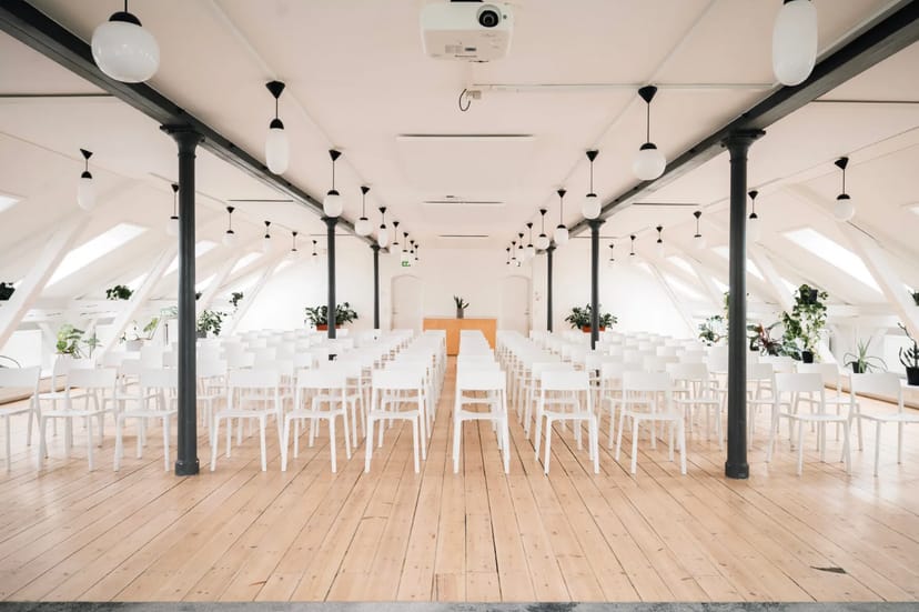 Modern event space with white chairs, ideal for meetings and presentations.
