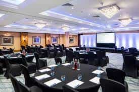 Buckholt Suite at Delta Hotels: elegant corporate event space with round tables and stage.