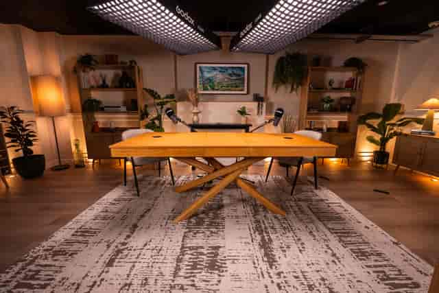 Podcast recording studio with wooden table, cozy atmosphere for creative meetings.