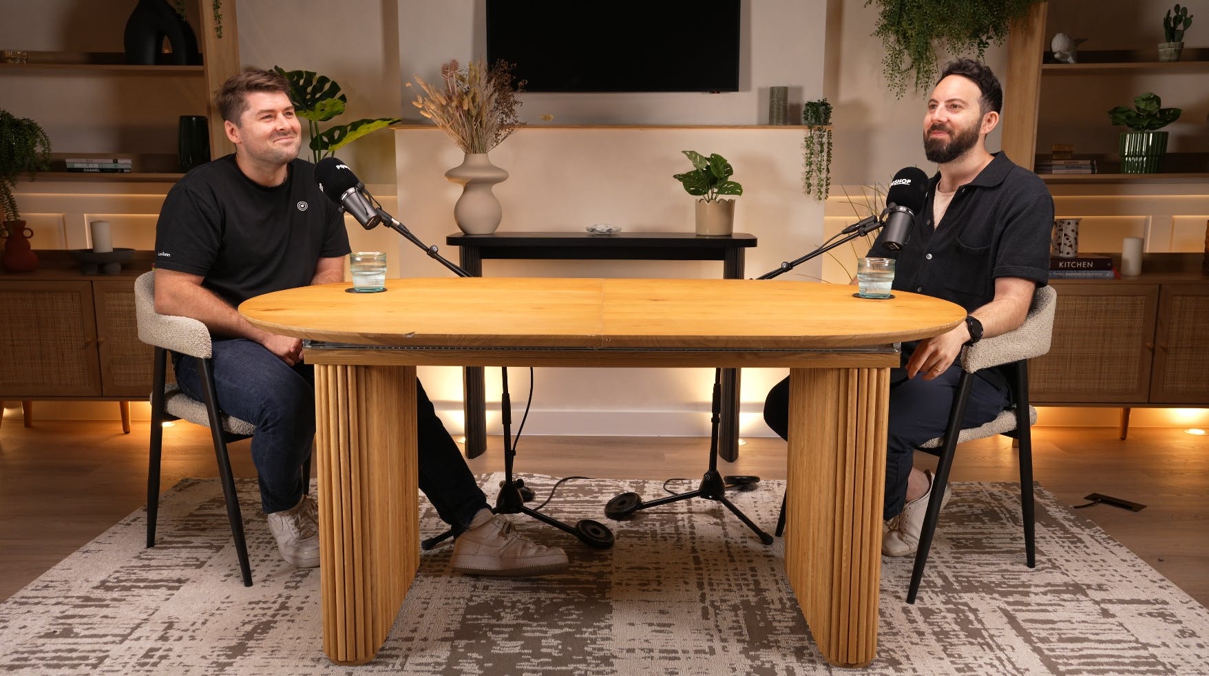 Podcast recording studio with stylish table, microphones, and warm lighting for engaging discussions.