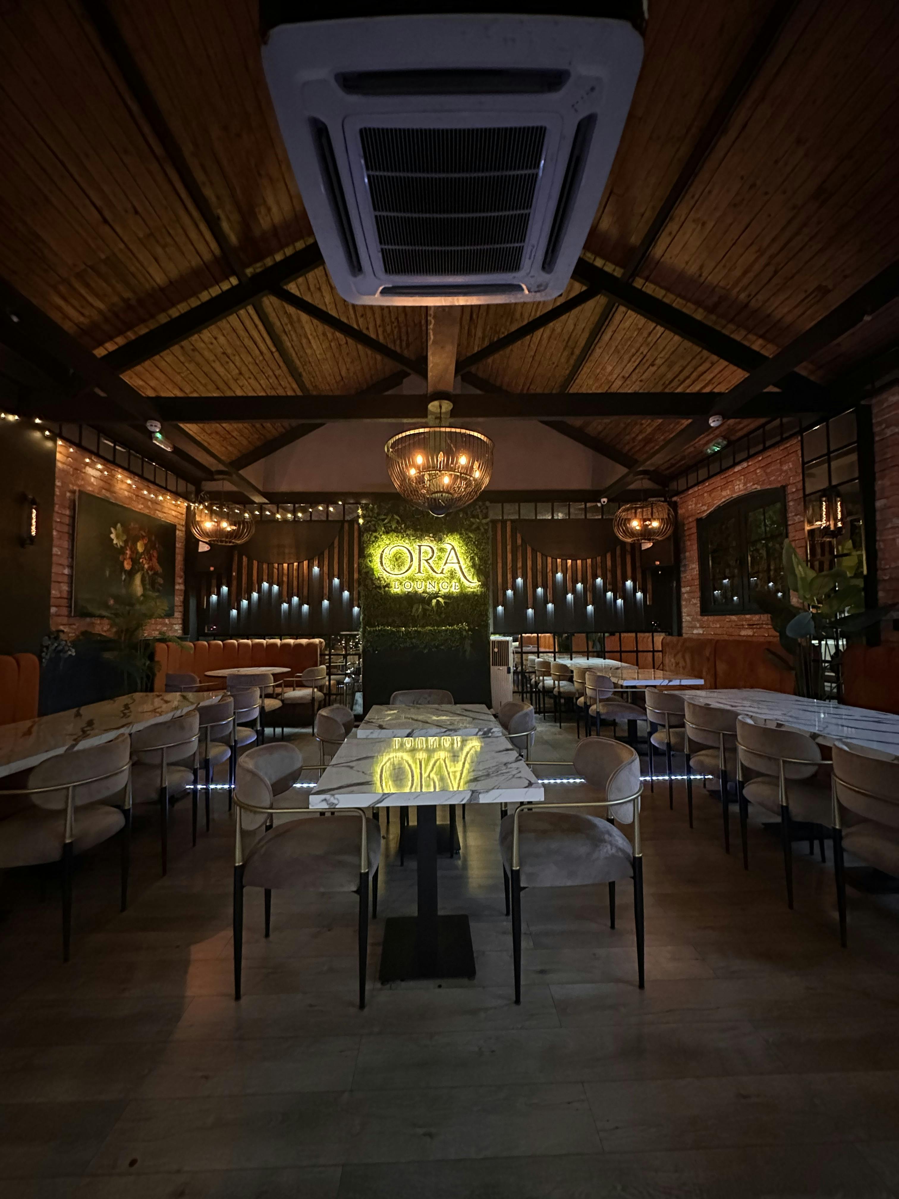 Stylish Ora Lounge event space with elegant chandeliers for gatherings and meetings.