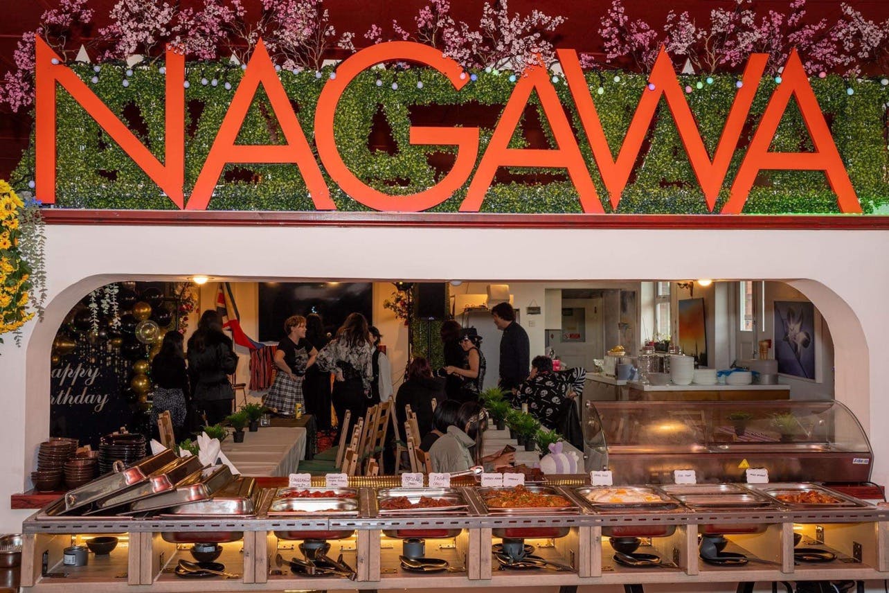 Churchill Hotel event space with "NAGAWA" sign, buffet setup for celebrations and networking.