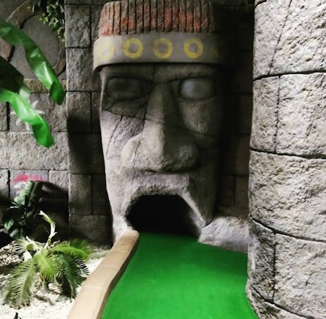 Jungle Rumble Birmingham entrance with stone face, ideal for team-building mini-golf events.