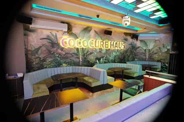 Vibrant Cococure Haus event space with modern seating and tropical backdrop for gatherings.