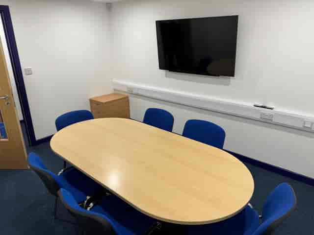 Modern UK training centre meeting room with oval table, ideal for collaborative discussions.