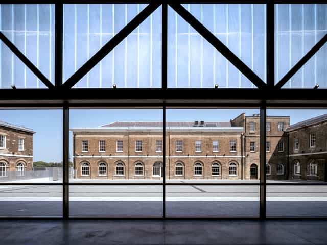 Modern event space with large glass windows in Woolwich Works, ideal for meetings and conferences.