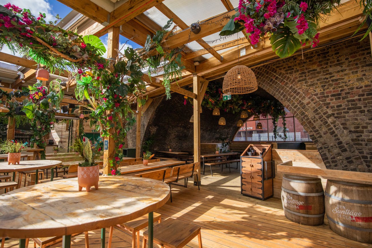 Vibrant Pergola Brixton event space with arched brick wall, ideal for gatherings and networking.