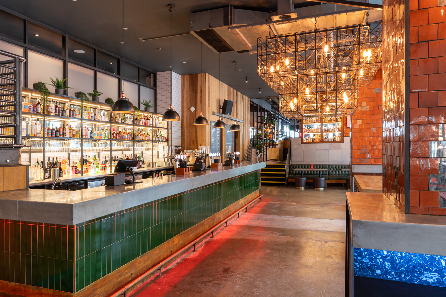 Stylish bar area with vibrant lighting, ideal for networking events and social gatherings. - Banner