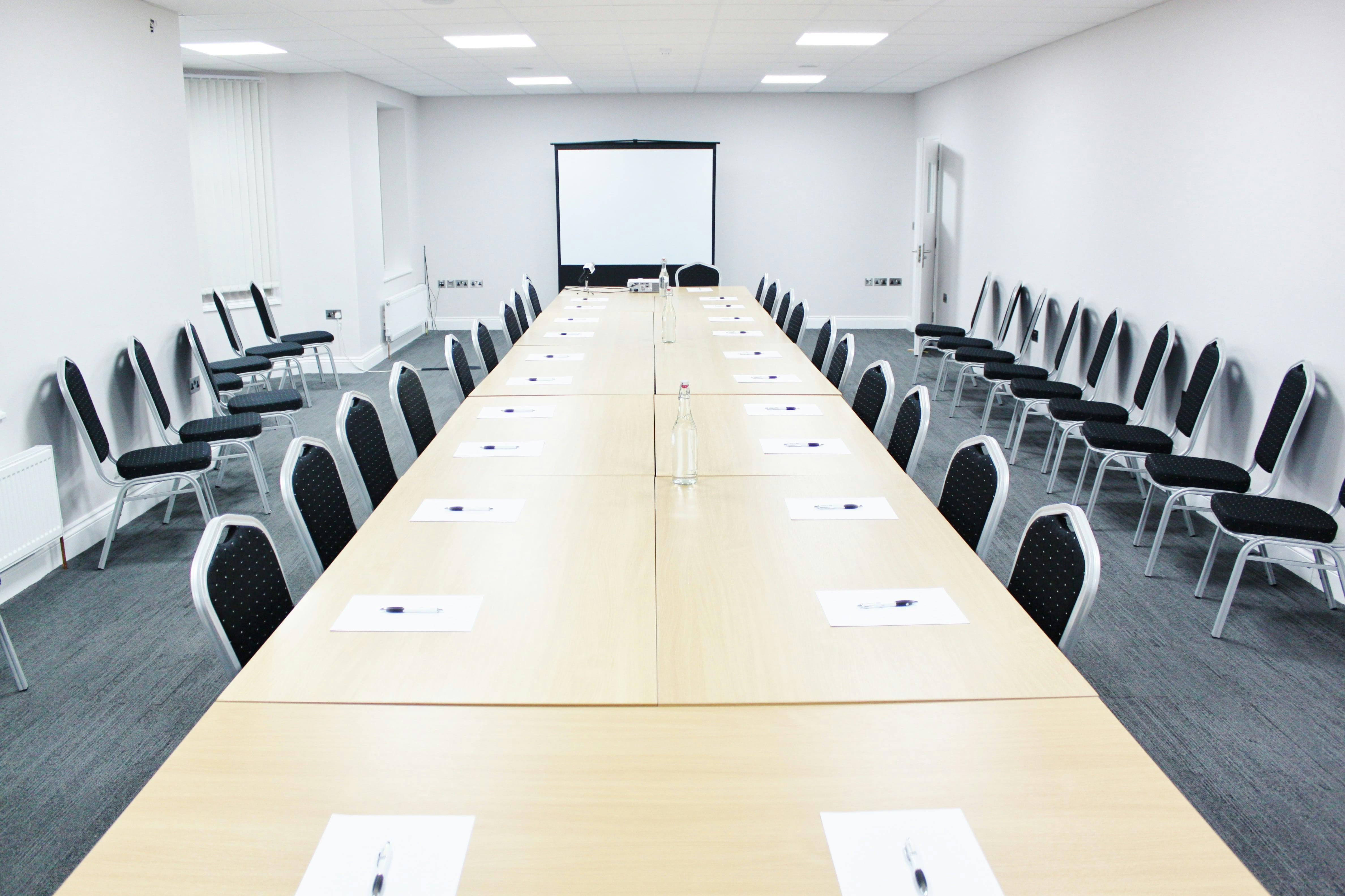 Conference room with long table, ready for professional workshops and strategy sessions.