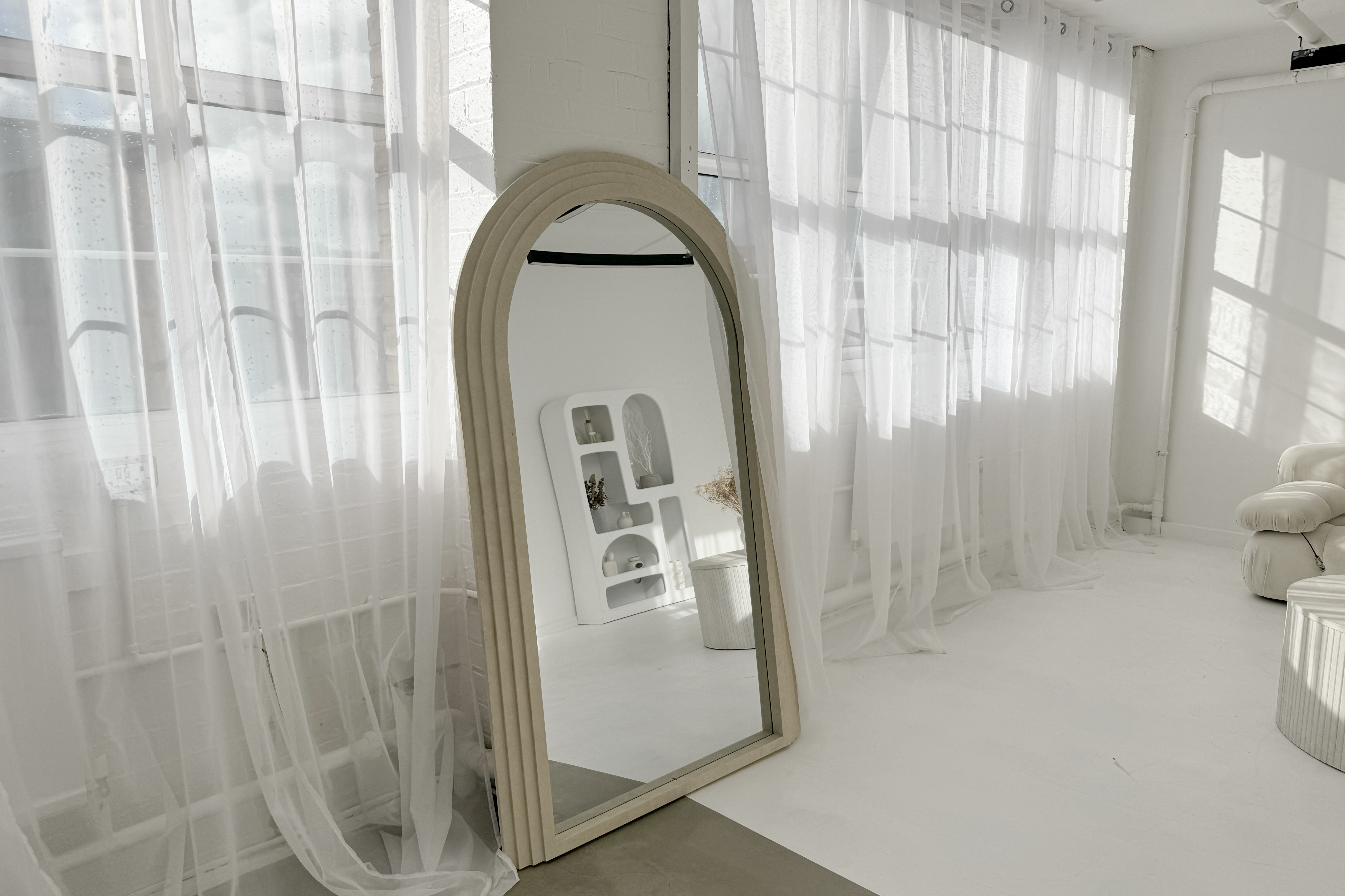 Bright event space with large windows and elegant arch mirror at Sumei Studios. - Banner