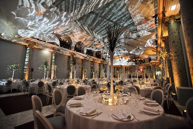Elegant event space with round tables and dynamic lighting for weddings and corporate events.