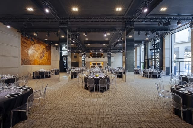 Modern event venue with elegant round tables, ideal for corporate meetings and receptions.