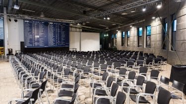 Spacious expo venue with black chairs, ready for presentations and networking events.