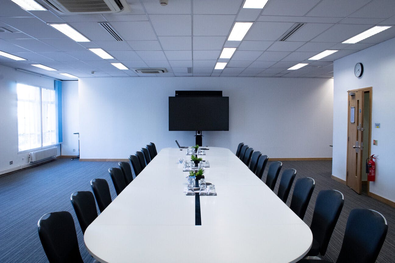 Modern conference room with sleek table, ideal for meetings and presentations.