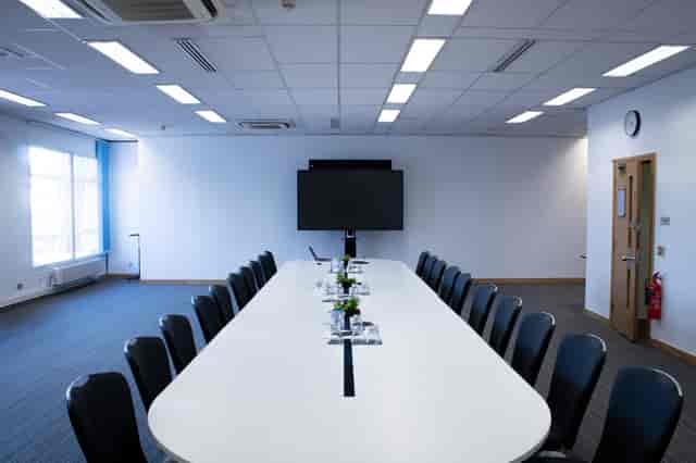 Modern conference room with sleek table, ideal for meetings and presentations.