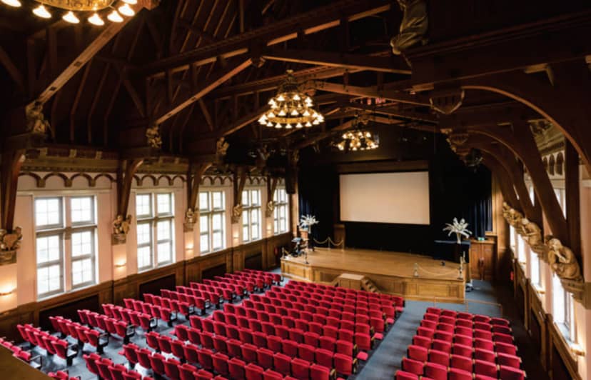 Spacious auditorium with wooden ceiling, ideal for corporate events and performances.