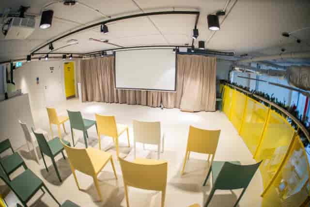 Versatile event space at Dugdale Arts Centre with colorful chairs for presentations and workshops.