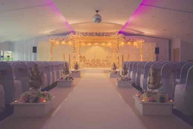 Elegant wedding ceremony setup at The Hive London with floral altar and draped chairs.