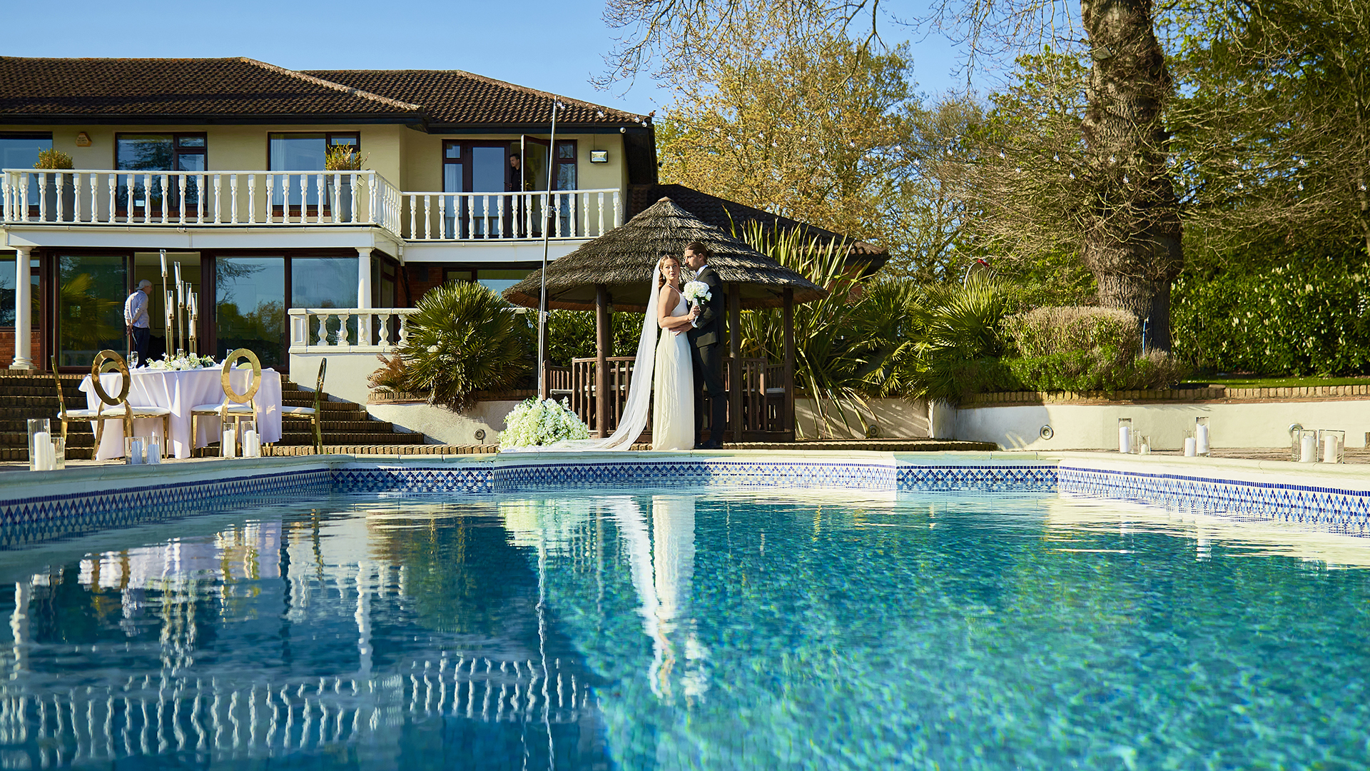 Outdoor wedding venue at The Villa Mansion with serene pool and lush greenery.