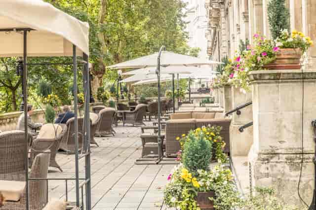 Charming outdoor event space at The National Liberal Club with lush greenery and umbrellas.