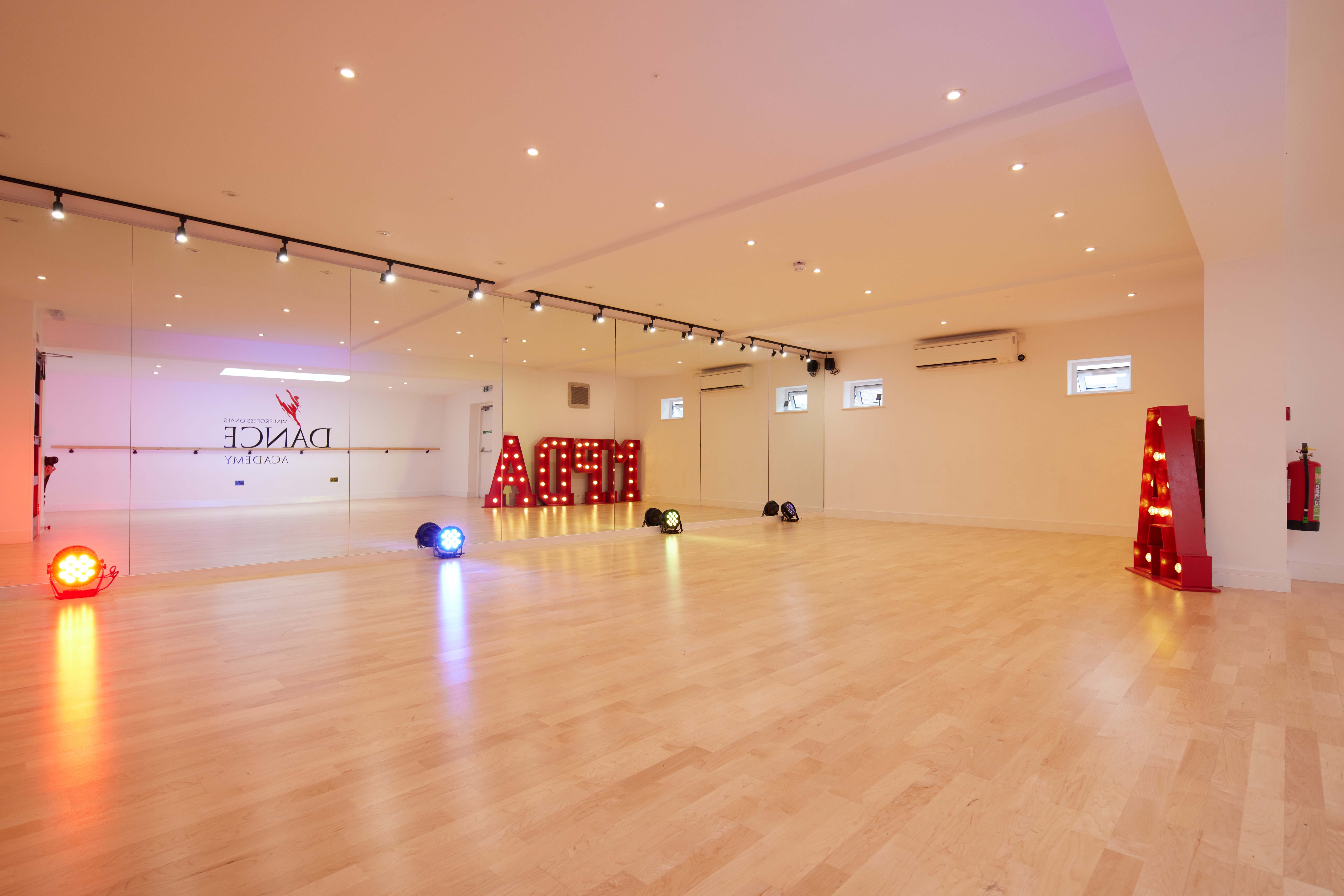 Versatile dance studio with polished floors, ideal for workshops and events.