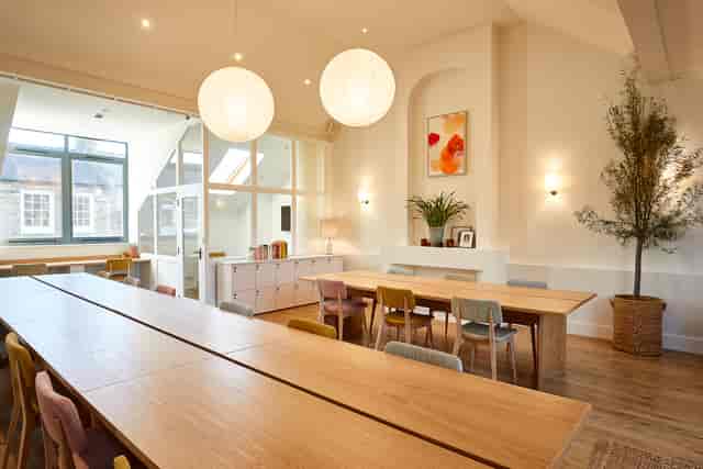 Bright meeting space with wooden table, perfect for workshops and corporate gatherings.