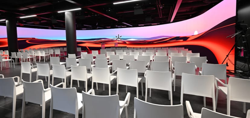LED stage setup with white chairs for a presentation in a modern event space.