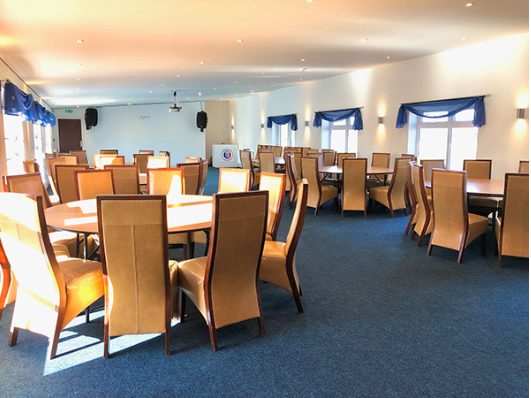 Spacious Castle Suite venue with elegant blue accents for meetings and gatherings. - Banner