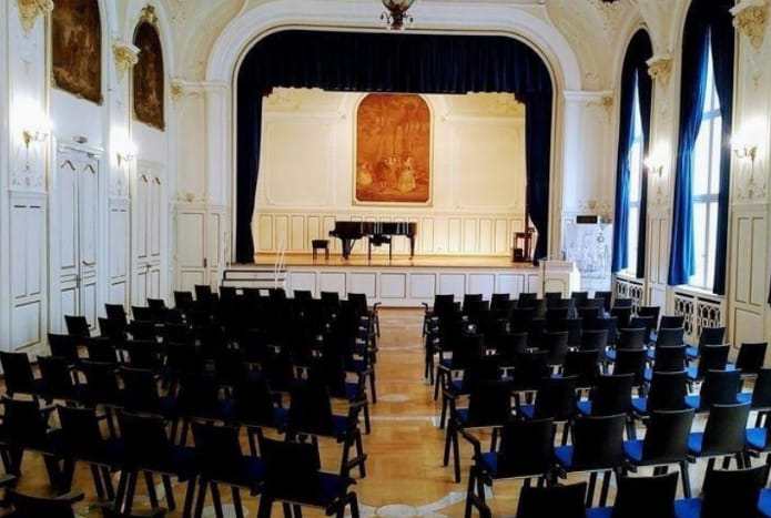 Elegant ballroom with grand piano, ideal for concerts and formal events.