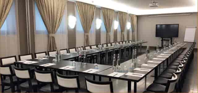 Fornasetti meeting room setup with U-shaped tables for professional events and workshops.