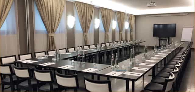 Fornasetti meeting room setup with U-shaped tables for professional events and workshops.