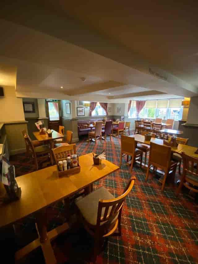 Cozy meeting space at The Bowling Green with wooden tables for events and gatherings.