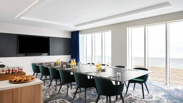 Modern Bow Suite meeting room with large table, ideal for corporate events and presentations.